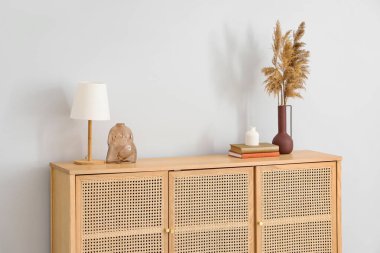 Kitaplı lamba ve şık ahşap çekmeceler üzerine dekorasyon odası beyaz duvarın yanında.