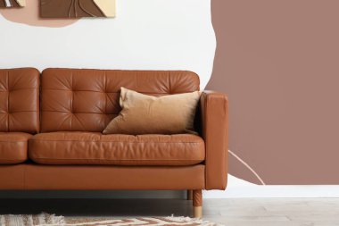 Şık oturma odasında yumuşak yastıklı kahverengi kanepe.