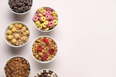 Bej arka planda farklı mısır gevrekleri olan kaseler