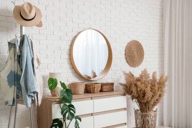 Hasır sepetli, aynalı ve elbise askılı koridorun içi.