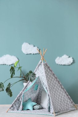 Nane duvarının yanında çadır ve çiçek bitkisi olan modern çocuk odası, yakın plan.