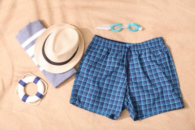 Erkekler için şort ve kumdaki aksesuarlar.