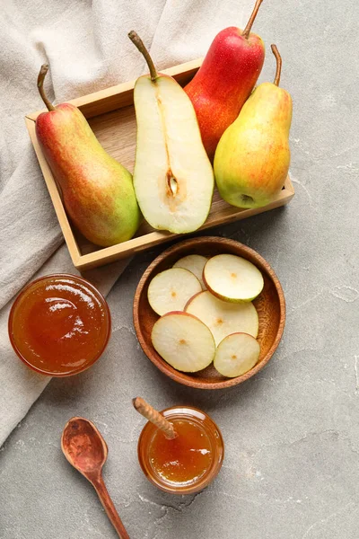 Cam kavanoz ve armut reçeli. Gri masa üzerinde ahşap kutu.