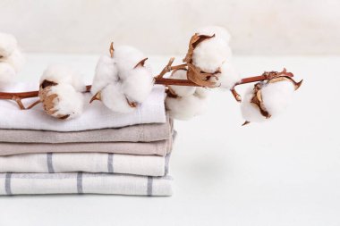 Arka planda pamuk dalı olan temiz havlular yığını