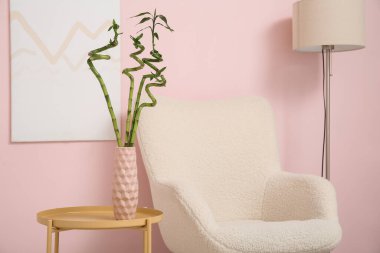 Beyaz koltuklu, standart lamba ve bambu saplı şık bir oturma odası.