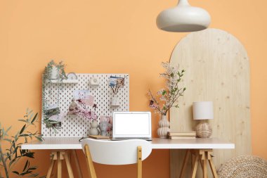 Ofiste boş dizüstü bilgisayarı, tahta ve çiçek açan dalları olan işyeri