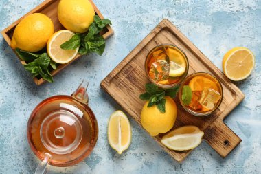 Mavi arka planda nane ve turunçgil meyveli limonlu buzlu çay.