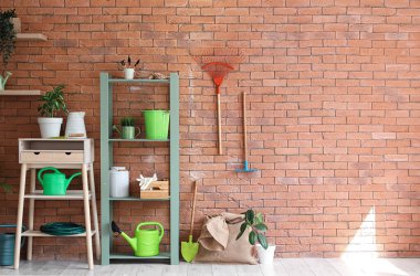 Raf ünitesi, masa ve bahçe aletleri ile atölyenin içi