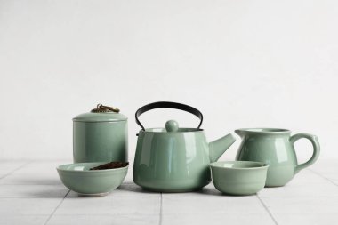 Beyaz ahşap masada yeşil çay seti