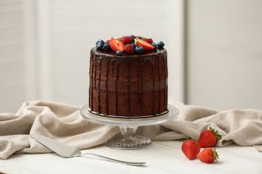 Mutfaktaki masada taze böğürtlenli ve spatulalı lezzetli çikolatalı pasta.