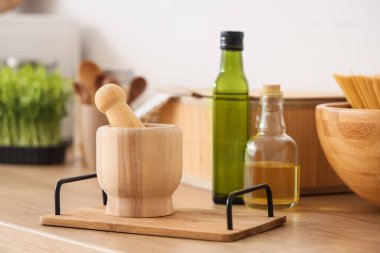 Mutfak tezgahında ahşap havan ve tokmak tepsisi, yakın plan.