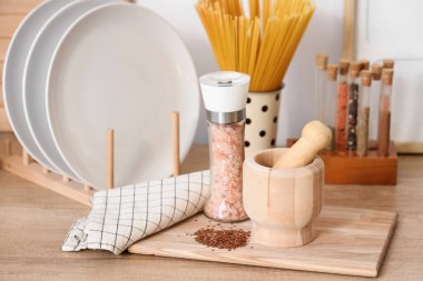 Kabuklu ahşap havan, keten tohumu ve deniz tuzu tezgahta, yakın plan.