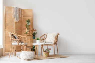 Hasır koltuklu, ahşap perdeli ve bitkilerle aydınlatma odasının içi