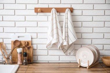 Mutfaktaki beyaz tuğla duvara asılı temiz peçeteler.