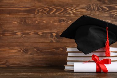 Tahta arka planda kitap yığını ve diploması olan havan topu tahtası.