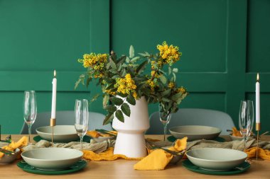 Gözlüklü, yanan mumlu ve çiçek açan ağaç dallı zarif bir masa.