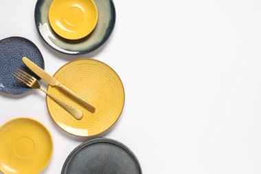 Beyaz arka planda çatal bıçaklı seramik tabaklar