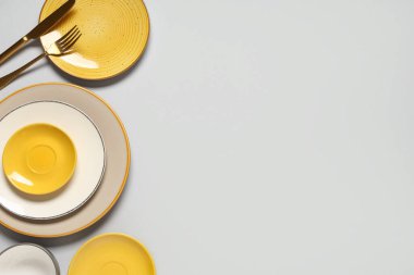 Gri arkaplanda temiz tabaklar ve çatal bıçak takımı