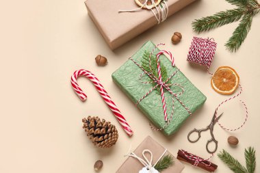 Noel süslemeleri, kurutulmuş portakallar ve bej arka planda ambalaj malzemeleriyle eko kağıdına sarılı hediye kutuları