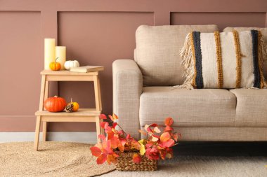 Sonbahar dekoru, rahat kanepesi ve merdiveni olan bir oturma odası.