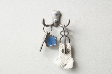 Evin anahtarları duvardaki kancalarda asılı.