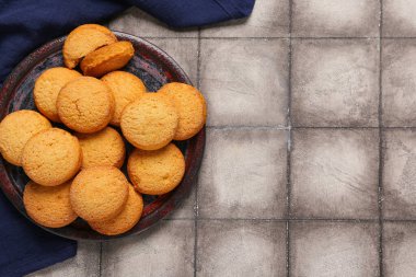 Gri fayans zemininde tatlı kurabiyeler olan tabak