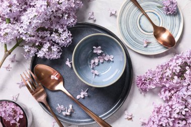 Gri arkaplanda leylak çiçekleri olan güzel bir masa.