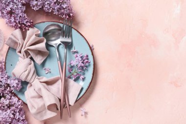 Pembe arka planda leylak çiçekleri olan güzel bir masa.