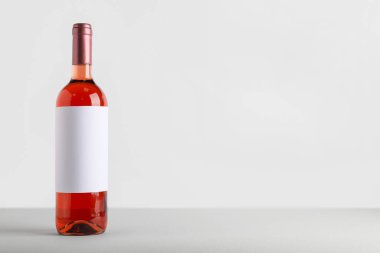 Beyaz arka planda boş etiketli bir şişe şarap.