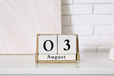 3 AĞUSTOS tarihli küp takvimi beyaz tuğla duvarın yanında, yakın plan.