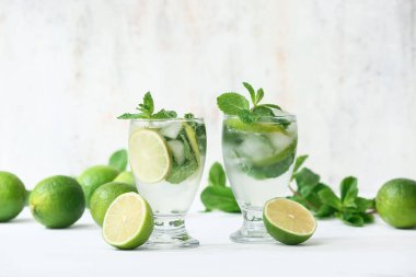 Beyaz arka planda taze mojito kokteyli ve nane şekeri.