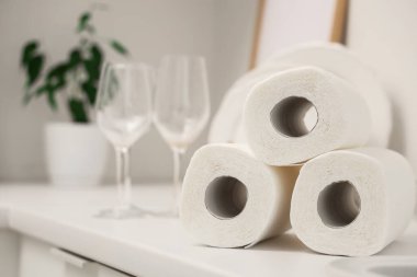 Mutfaktaki masada bardakların yanında kağıt havlu ruloları, yakın plan.