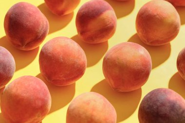 Tatlı olgun şeftaliler sarı arka planda, yakın plan