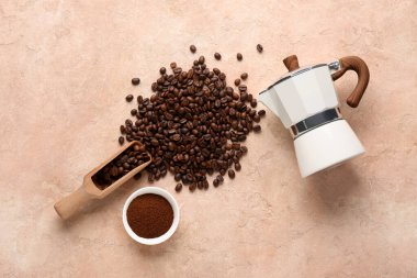 Kahve çekirdekli ahşap kepçe, toz ve gayzer kahve makinesi bej grunge arka planda.