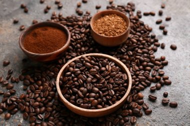 Kahve çekirdekli kaseler ve gri arkaplanda pudra.