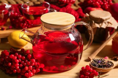 Ahşap zemin üzerinde cam çaydanlık sıcak viburnum çayı