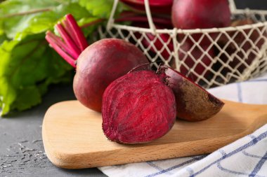 Tahta tahta ve sepet ve siyah arka planda taze pancar kökleri.