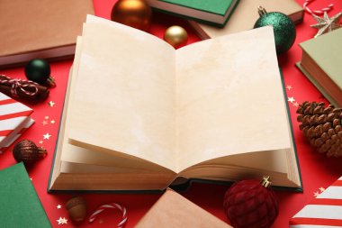 Kırmızı arka planda Noel topları olan boş bir kitap, yakın plan