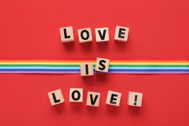 Gökkuşağı kurdelesi ve kırmızı arka planda aşk var. LGBT kavramı