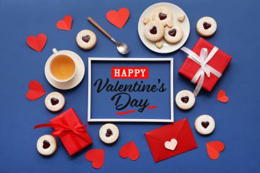 Sevgililer günü için içinde tatlı kurabiyeler, çay ve hediyeler olan tebrik kartı.