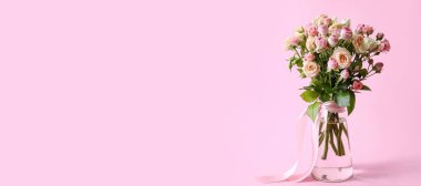 Üzerinde pembe arkaplan üzerine güzel güller olan bir vazo ve metin için yer.