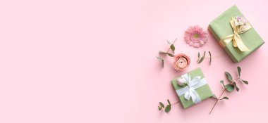 Pembe arka planda güzel çiçekli hediye kutuları ve metin için boşluk
