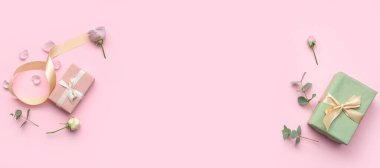 Pembe zemin üzerinde güller olan hediye kutuları ve metin için boşluk