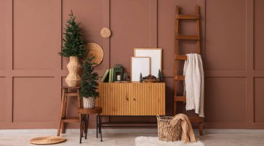 Odanın içinde Noel ağaçları, merdiven ve kozalaklı kozalaklı ahşap kozalaklar var.