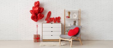 Oturma odasının içinde koltuk, çekmeceler ve hediyeli balonlar var. Sevgililer Günü kutlaması