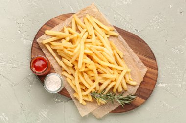 Lezzetli patates kızartması, yeşil arka planda tuz ve ketçap.