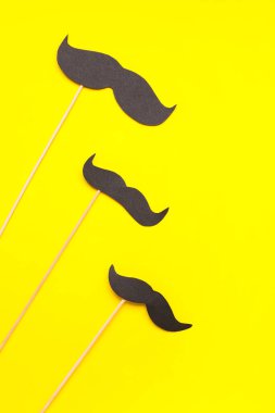 Sarı arka planda kağıt bıyıklar.