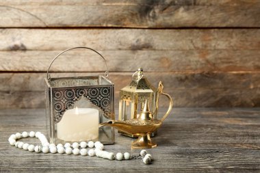 Tahta arka planda tespih taşıyan Müslüman lambaları