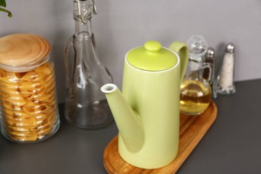 Siyah masanın üzerinde farklı mutfak malzemeleri olan çaydanlık.