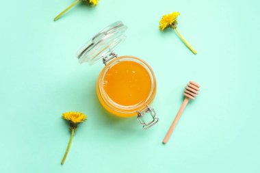 Turkuaz arka planda karahindiba balı kavanoz.